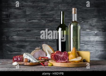Wein, Käse und Fleisch auf einem rustikalen Holztisch essen Hintergrund Stockfoto