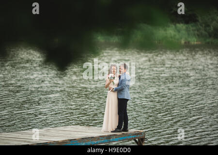 Braut und Bräutigam zu Fuß am Fluss, Lächeln, küssen Stockfoto