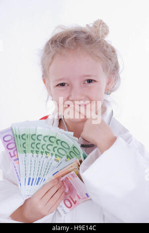 Sieben-Jahr-altes Mädchen verkleidet als Arzt mit Geld Stockfoto