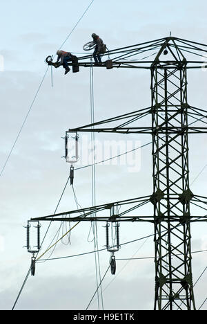 Zwei Männer arbeiten auf eine elektrische pylon Stockfoto