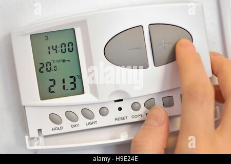 Hand drücken des Knopfes auf digitaler thermostat Stockfoto