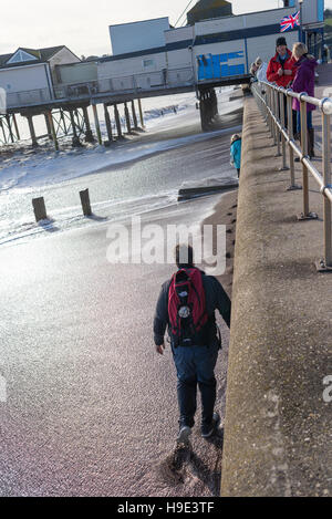 Teignmouth, Devon, UK. Ein Mann ruft seine Füße nass von einer Welle, nachdem wie weit sich die Flut verkennen gegangen war. Stockfoto