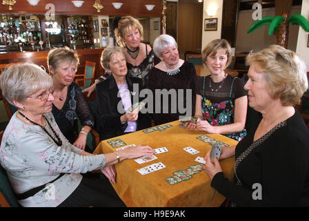 Eine Gruppe von sieben Frauen-Bridge-Spieler, die an einem einzigen Tisch sitzen. Stockfoto