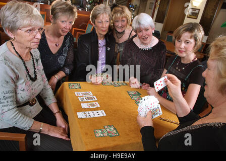 Eine Gruppe von sieben Frauen-Bridge-Spieler, die an einem einzigen Tisch sitzen. Stockfoto