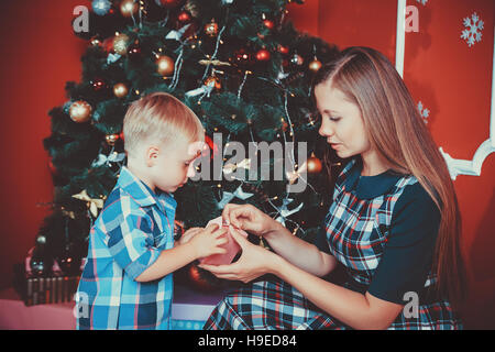 Schöne Portrait der glücklichen Mutter und Sohn auf dem Hintergrund der Weihnachtsbaum im neuen Jahr Zimmer mit Geschenken. Die Idee für Postkarten. Soft Focus.sh Stockfoto