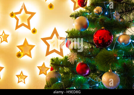 Nahaufnahme von Weihnachten - Baum Hintergrund im Wohnzimmer des Hauses mit leuchtenden Sternen auf der Wand Stockfoto