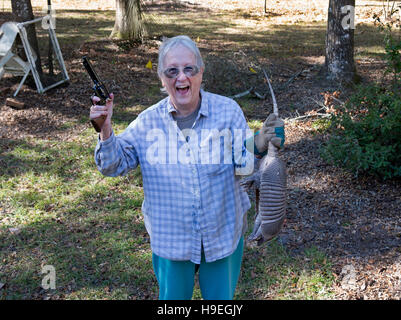 Ältere Frau Taschen ein Gürteltier in Nord-Zentral-Florida. Stockfoto