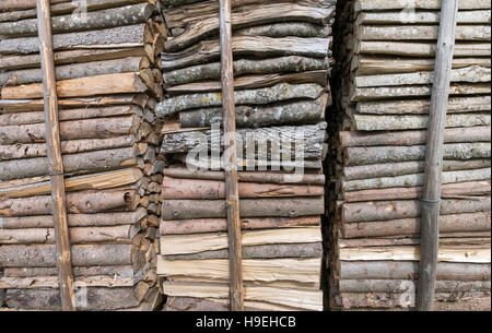 Gestapelte Holz gegen Stangen Stockfoto