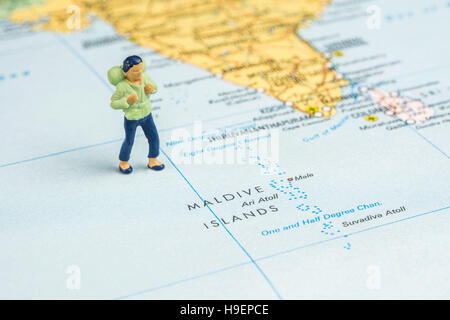 Nahaufnahme von Miniatur Figur des jungen Reisenden steht auf große Karte neben Malediven Stockfoto