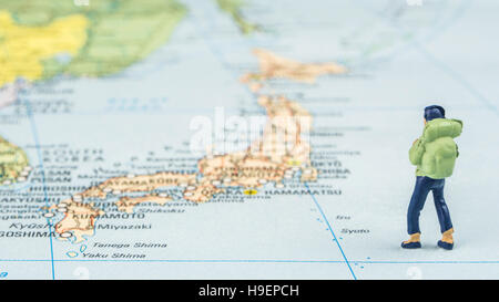 Nahaufnahme von Miniatur Figur des jungen Reisenden steht auf große Karte neben Japan Stockfoto