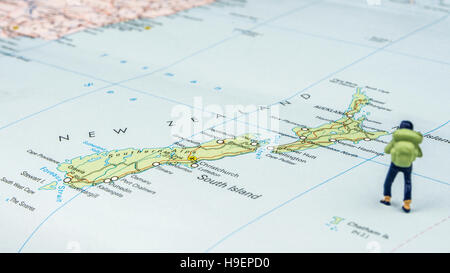 Nahaufnahme von Miniatur Figur des jungen Reisenden steht auf große Karte neben Neuseeland Inseln Stockfoto