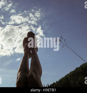 Kaukasische mit Beine angehoben, blauer Himmel Stockfoto