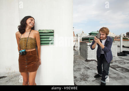 Gemischtes Rennen paar spielen auf Dachterrasse mit Videokamera Stockfoto