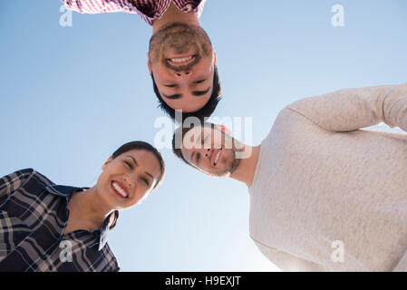Lächelnden Freunde verlieren unter blauem Himmel Stockfoto