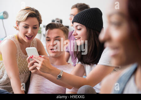 Lächelnden Freunde SMS auf Handy Stockfoto