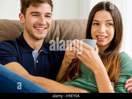 Junges Paar auf dem Sofa Kaffee trinken Stockfoto