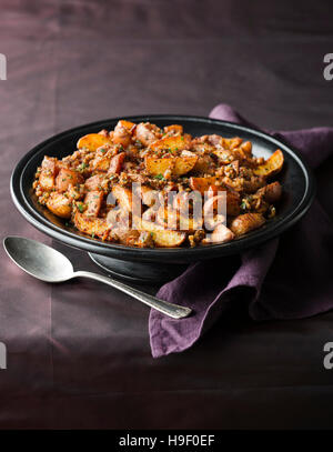Teller mit Bratkartoffeln und Löffel Stockfoto