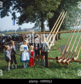 Oberbayern, 1980er. Landkreis Rosenheim. Kinder Beim Alphorn-Treffen in der Gemeinde Flintsbach. Oberbayern, 1980er Jahre, Landkreis, Gemeinde Flintsbach Rosenheim. Bayerische Kinder mit Alphörnern. Stockfoto