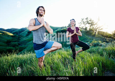 Lächelnde paar üben Yoga am Berg Stockfoto