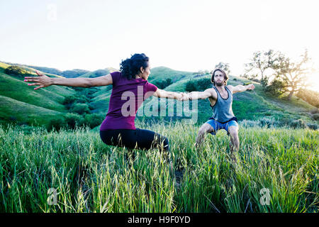 Paar Hand in Hand und üben Yoga am Berg Stockfoto