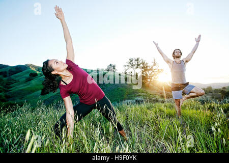 Paar üben Yoga am Berg Stockfoto