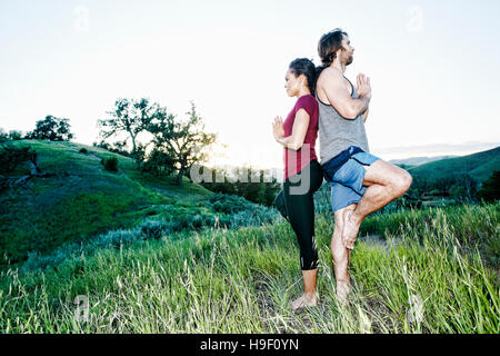 Paar üben Yoga am Berg Stockfoto