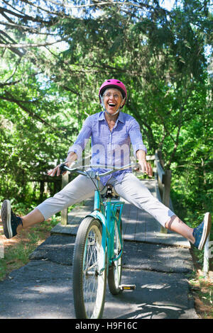 Kaukasische Frau sitzen auf dem Fahrrad mit gespreizten Beinen Stockfoto