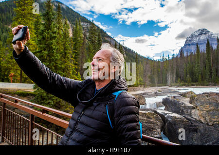 Kaukasischen Mann posiert für Handy Selfie in der Nähe von Berg Stockfoto