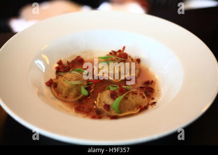 Kohl-Ravioli mit knusprigem Speck in Pfeffersoße Stockfoto