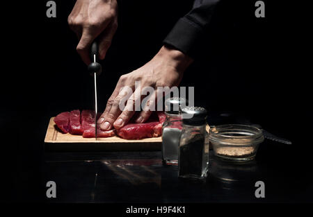Nahaufnahme der Köche Hände Fleisch hacken Stockfoto