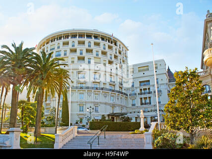 Der Spaziergang entlang der schattigen Straßen von Monte Carlo mit dem Blick auf die Seitenfassade des Luxus Hotel de Paris, Monaco. Stockfoto