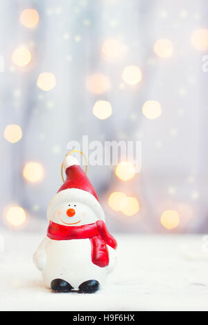 Weihnachten und Neujahr Hintergrund - Schneemann Figur gegen Weihnachtsbeleuchtung mit Textfreiraum Stockfoto