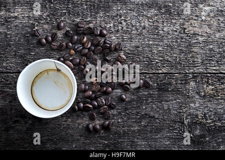 Pappbecher betrunken Kaffee mit Kaffee gemahlen auf Holztisch und Kaffeebohnen in strukturiertem Hintergrund. Kaffee-Zeit, Tasse leer, zum mitnehmen Stockfoto