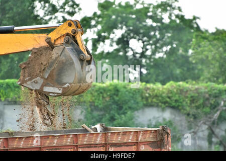 Bagger arbeitet mit staubigen roten Erde. Stockfoto