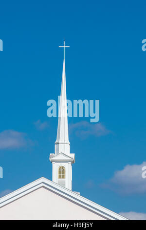 Große weiße Kirchturm mit Kreuz an der Spitze vor blauem Himmel in Punta Gorda, Florida Stockfoto