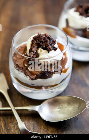 Paar von Karamell Schokolade Brownie Käsekuchen in Gläsern mit alten altmodischen Löffel Stockfoto