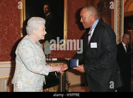 Königin Elizabeth II vergibt Zac Dominic aus St. Lucia mit der Mountbatten-Medaille im Rahmen eines Empfangs für die königlichen Leben sparen Gesellschaft am Buckingham Palace, London statt. Stockfoto