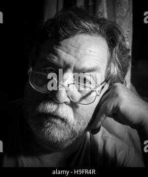 Monochrom schwarz / weiß Foto. Porträt eines traurigen erwachsenen Mannes mit einem grauen Schnurrbart. "Real People" Serie Stockfoto