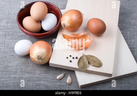 Draufsicht auf die Zutaten für das Kochen im Vintage-Stil - Eiern, Zwiebeln, Tomaten, Knoblauch und Gewürzen auf Textil-Hintergrund Stockfoto