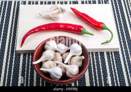 Hintergrund für das Kochen - Gewürz Cayenne Chili und Knoblauch in eine braune Schale auf einem Küchentisch Stockfoto