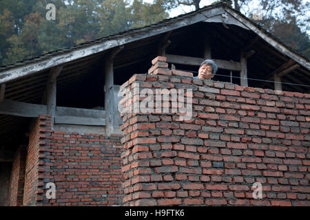 Ein Bauer sein privates Haus mit Ziegeln und Holz in einem kleinen abgelegenen Dorf in den Bergen von West-China. Stockfoto