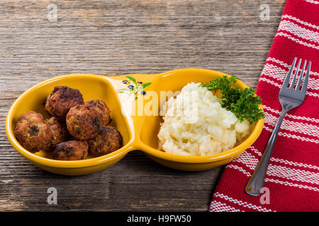 Fleischbällchen mit Kartoffelpüree auf dem Tisch in natürlichem Licht Stockfoto