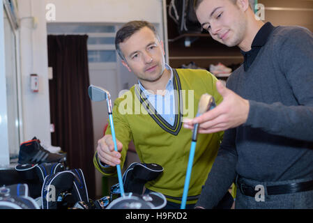 glückliche Frau mit Mann Golf Club im Store auswählen Stockfoto