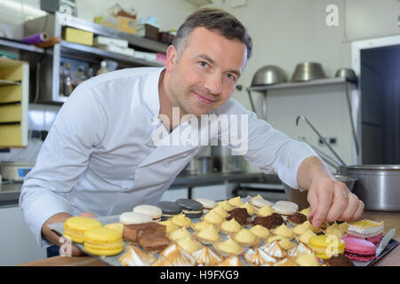 Baker Holding Tablett mit Kuchen Stockfoto