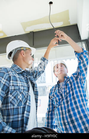 zwei Elektriker auswechseln Glühbirne zur Energiesparlampe Stockfoto