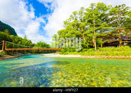 Blauer Himmel bricht durch die Wolken über Kappa-Bashi-Brücke über die klare alpine Gewässer des Flusses Azusa am Morgen in Kamikochi Stockfoto