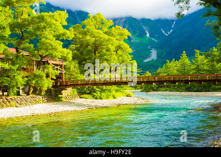 Mann, Kappa-Bashi Brücke mit Mount Hotaka Hintergrund am frühen sonnigen Morgen in den japanischen Alpen in Kamikochi Nagano Stockfoto