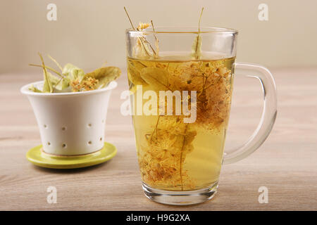 Kalk-Teetasse mit getrockneten Blüten. Glastasse Tee mit pflanzlichen Linden. Stockfoto