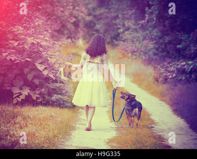 Junge Braut Hochzeit Kleid barfuß mit Hund auf der Landstraße zurück zu Kamera. Frau bringen Hochzeitsschuhe. Vintage Farbe. Boho-Chic-Stil Stockfoto