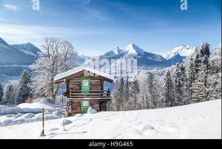 Winter Wunderland Bergkulisse der Alpen mit traditionellen Berghütte auf einem schönen kalten sonnigen Tag mit blauem Himmel Stockfoto